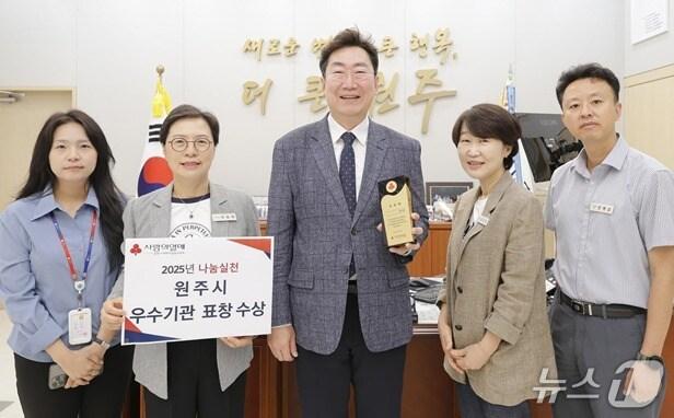 본문 이미지 - 강원 원주시가 최근 사회복지공동모금회 주관 '희망2025 나눔 캠페인'의 우수기관으로 선정돼 강원사회복지공동모금회로부터 기관 표창을 받은 가운데, 원강수 원주시장이 시청 집무실에서 시 관계자들과 이를 기념하는 사진 촬영에 나서고 있다. (원주시 제공. 재판매 및 DB금지) 2025.7.28/뉴스1