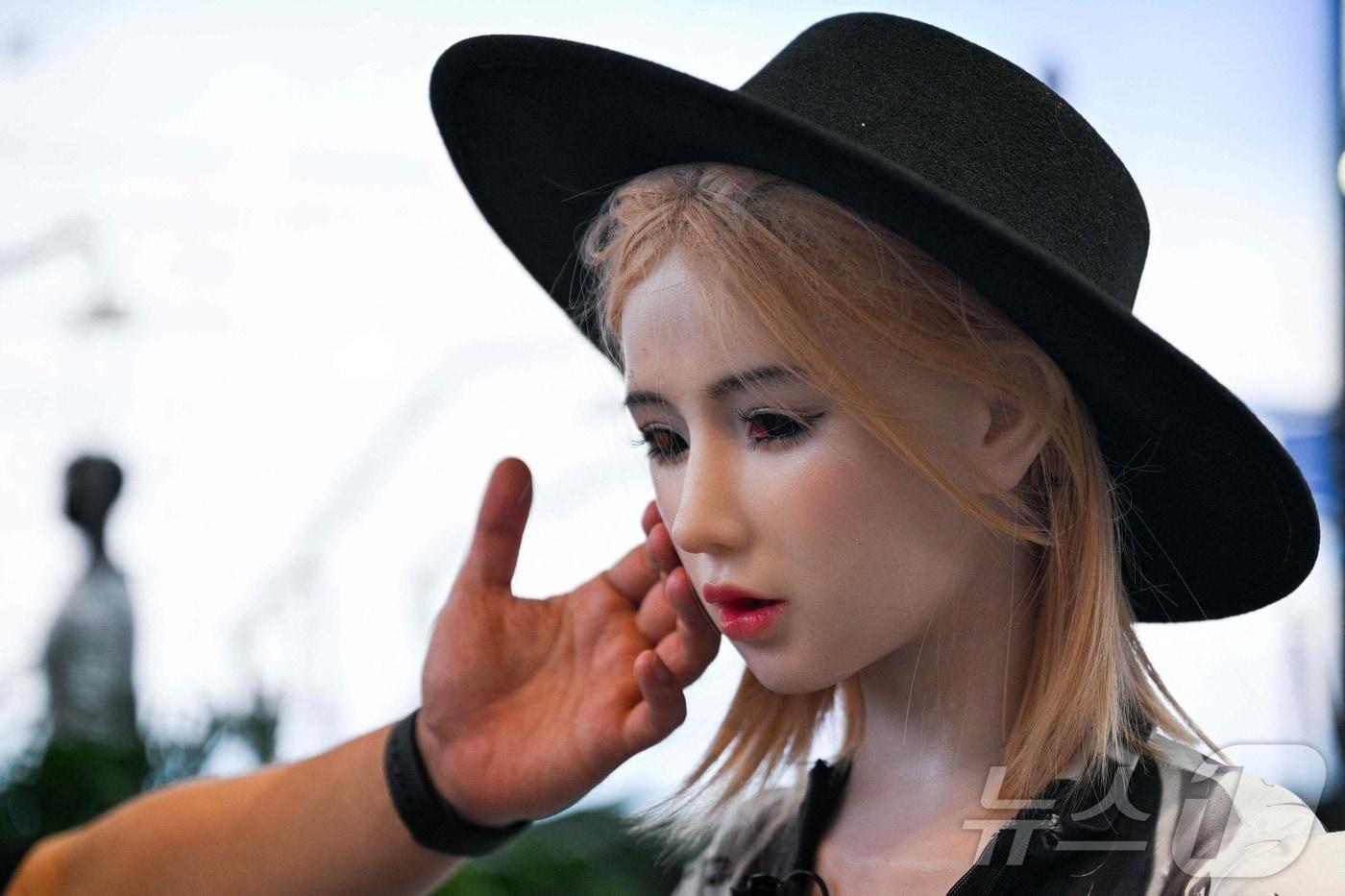 2025년 7월 28일, 중국 상하이 세계박람회 컨벤션센터에서 열린 세계 인공지능 회의&#40;WAIC&#41;에서 한 남성이 휴머노이드 로봇을 만지고 있다ⓒ AFP=뉴스1