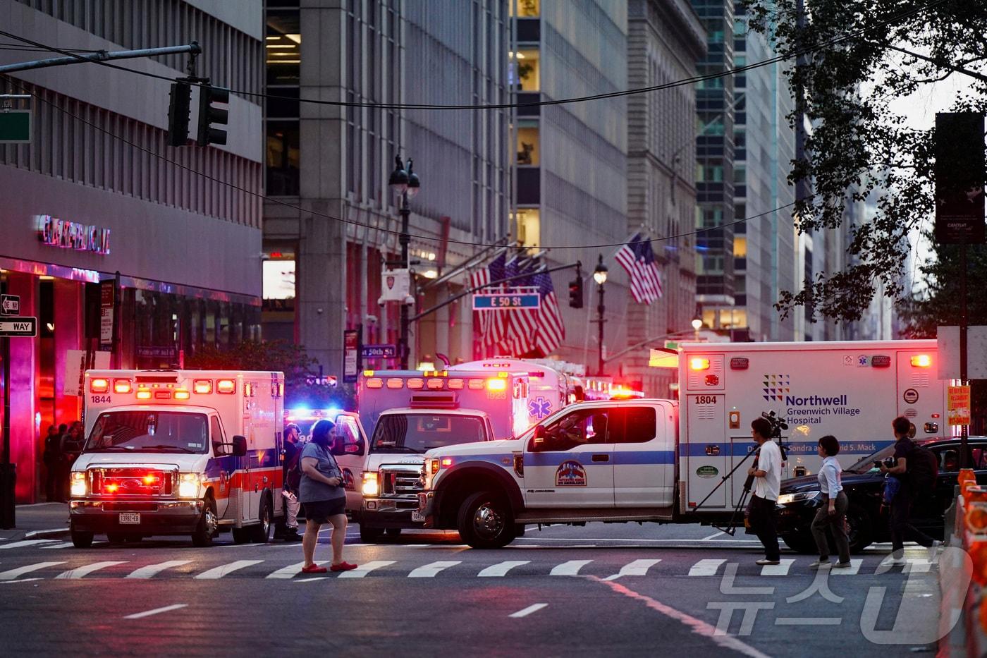 28일&#40;현지시간&#41; 미국 뉴욕시 맨해튼 지역 총격 사건이 발생한 현장 인근에서 언론 관계자들이 구급차 옆을 지나가고 있다.2025.07.28.ⓒ 로이터=뉴스1