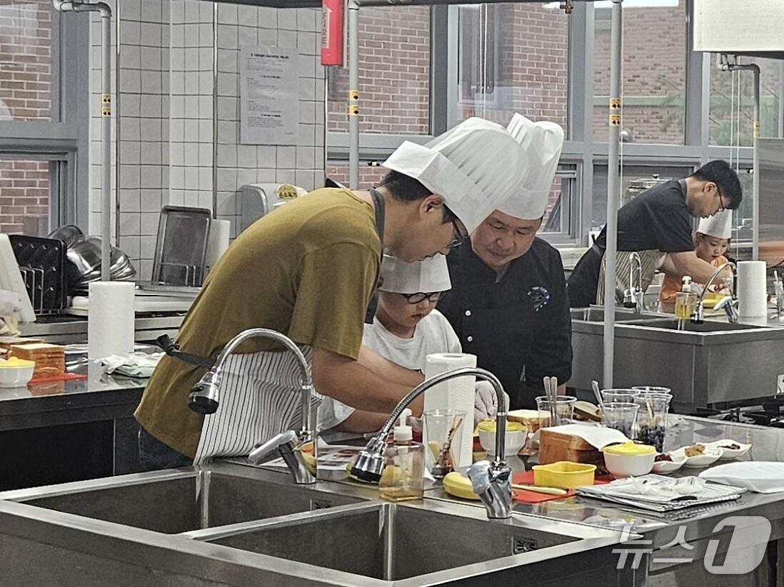 본문 이미지 - 1기 아버지 교실에 참가한 학부모들이 자녀와 함께 요리를 하고 있다.(화성오산교육지원청 제공)