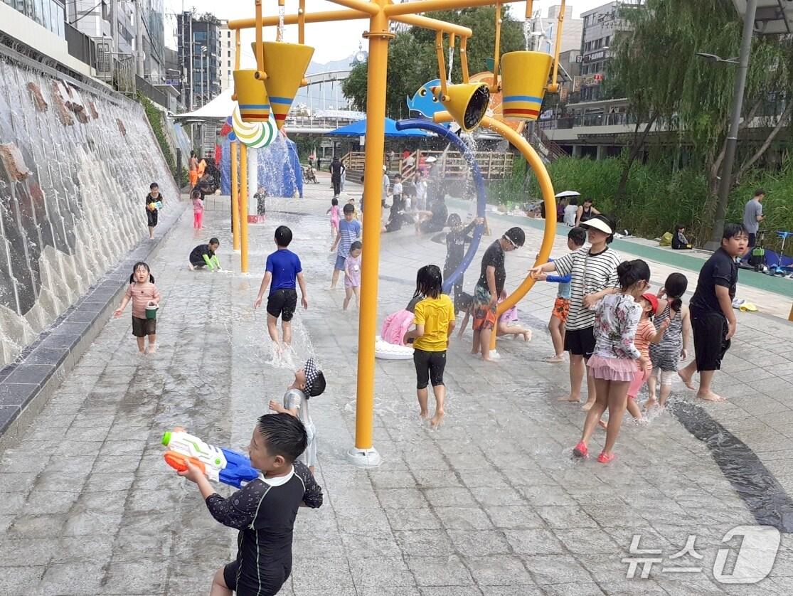 본문 이미지 - 별빛내린천 어린이 물놀이장에서 물놀이를 즐기는 주민들.(관악구청 제공)