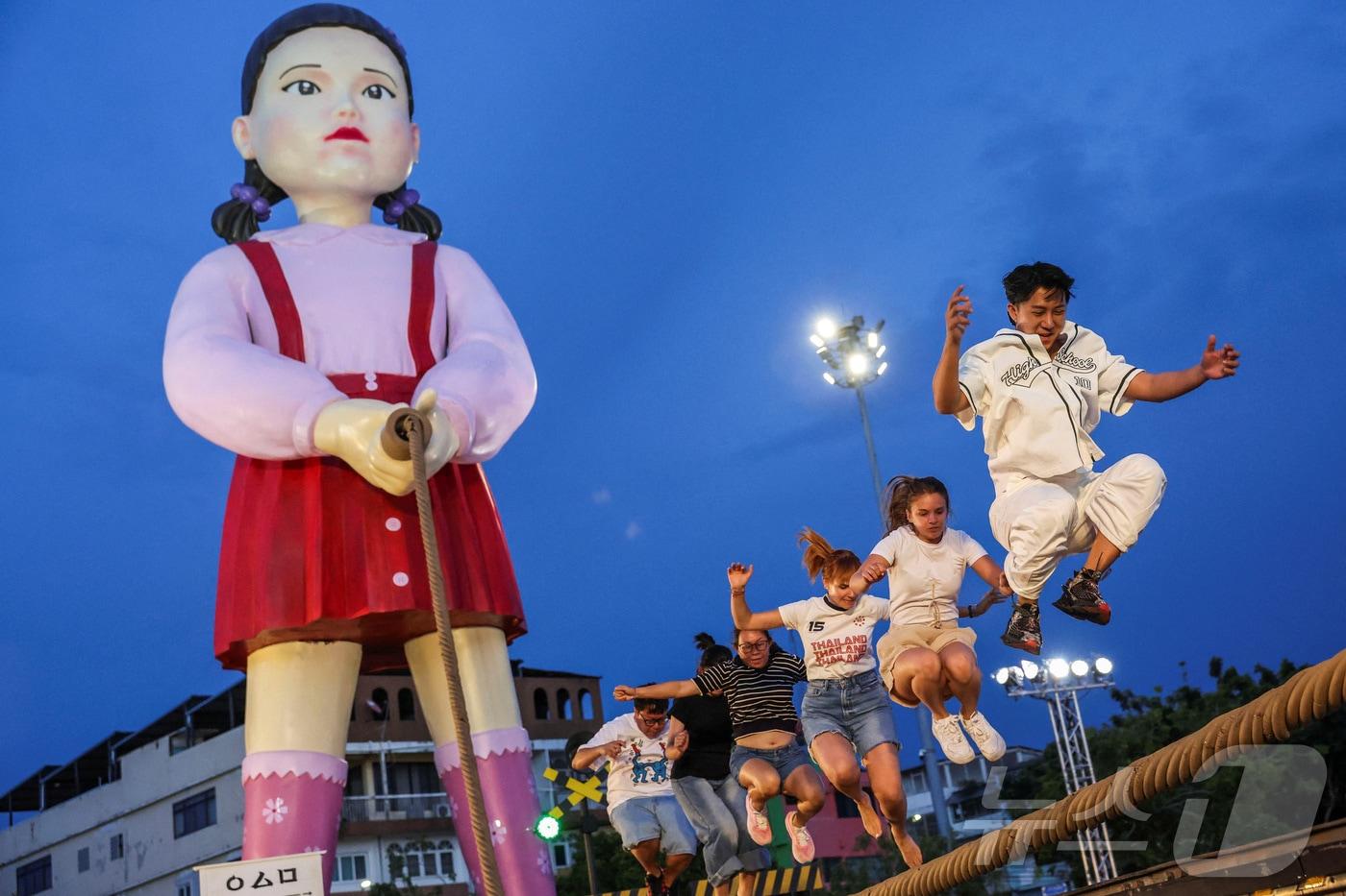 지난 30일(현지시간) 태국 방콩 시청 광장에서 열린 '오징어 게임 3' 홍보 행사에서 시민들이 줄넘기 게임을 하고 있다. ⓒ 로이터=뉴스1