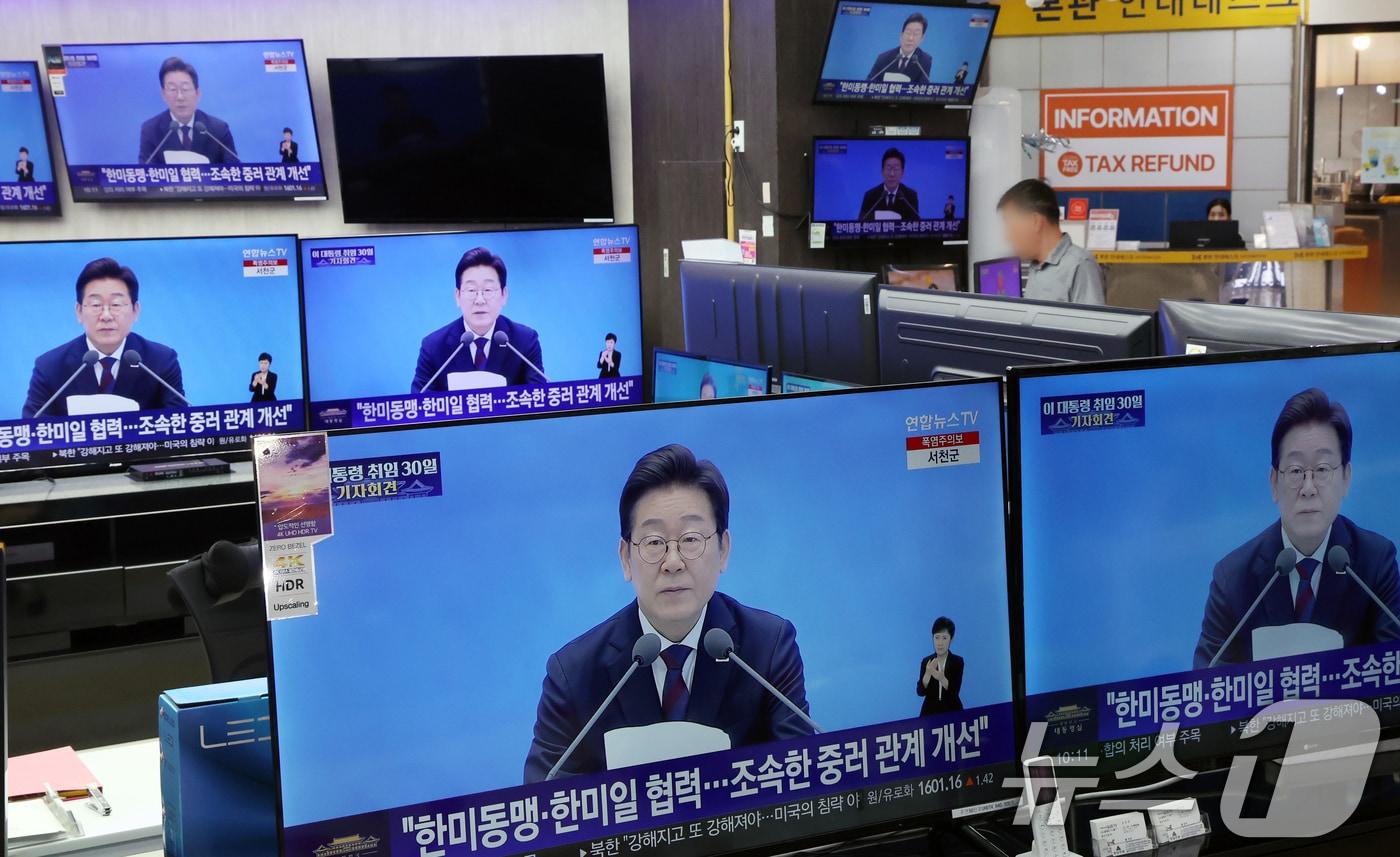 지난 7월 3일 서울 용산구 전자랜드 매장에서 상인이 &#39;대통령의 30일, 언론이 묻고 국민에게 답하다&#39;라는 이재명 대통령 기자회견을 보고 있다. 2025.7.3/뉴스1 ⓒ News1 김명섭 기자