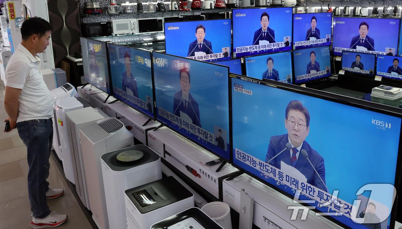 지난 7월3일 서울 용산구 전자랜드 매장에서 상인이 &#39;대통령의 30일, 언론이 묻고 국민에게 답하다&#39;라는 이재명 대통령 기자회견을 보고 있다. 2025.7.3/뉴스1 ⓒ News1 김명섭 기자