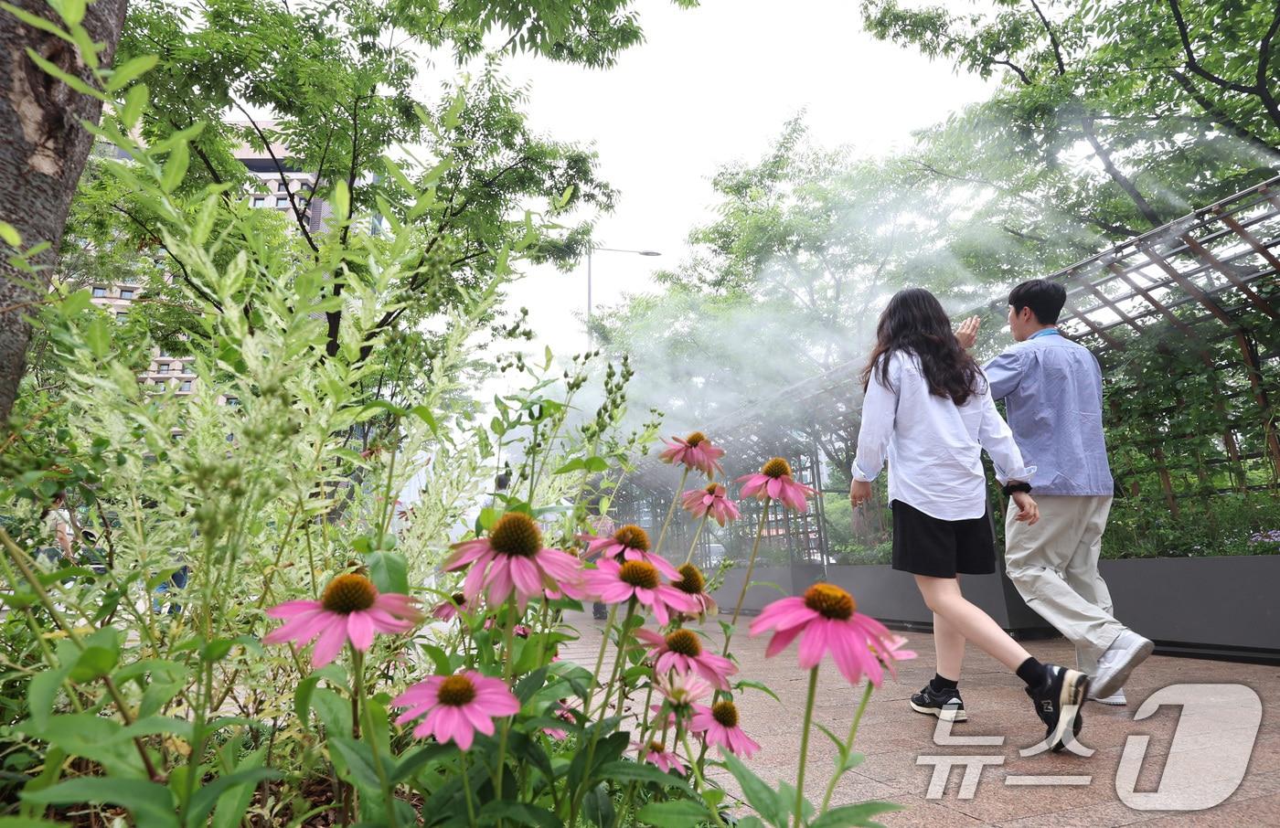 무더위가 이어지는 3일 오후 시민들이 서울광장에 설치된 쿨링포그 앞을 지나며 더위를 식히고 있다. 2025.7.3/뉴스1 ⓒ News1 구윤성 기자