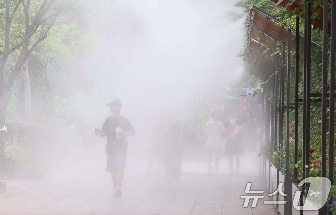 무더위가 이어지는 3일 오후 시민들이 서울광장에 설치된 쿨링포그 앞을 지나며 더위를 식히고 있다. 2025.7.3/뉴스1 ⓒ News1 구윤성 기자