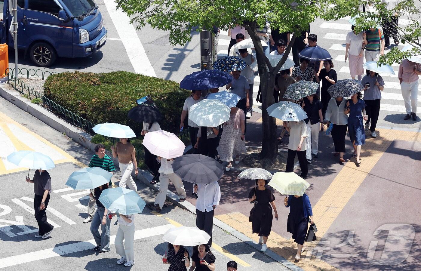 찜통더위가 이어지고 있는 3일 광주 북구청 교차로에 구청 공직자들이 점심시간 양산을 쓰고 이동하고 있다. (광주 북구 제공. 재판매 및 DB 금지) 2025.7.3/뉴스1 
