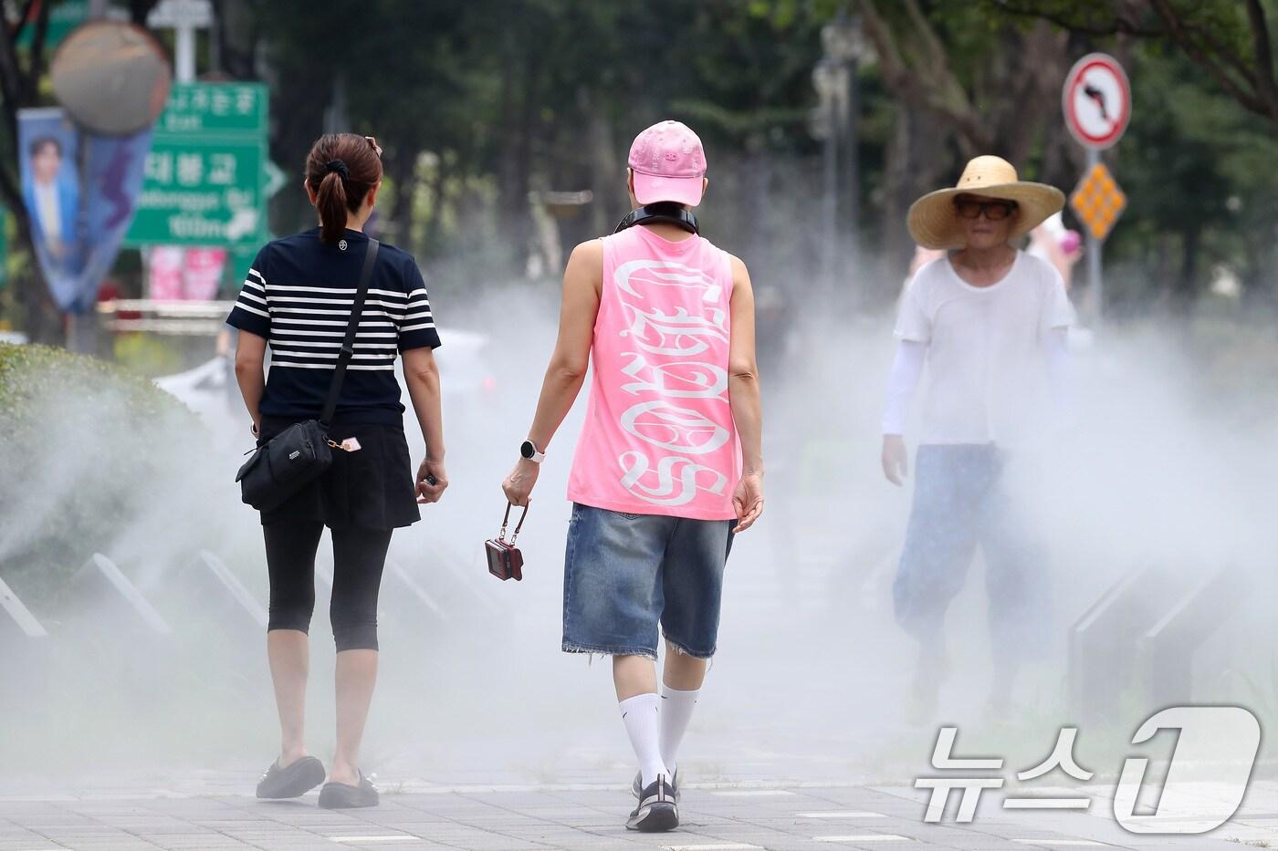일주일째 폭염특보가 이어진 3일 대구 중구 김광석길 입구에 가동된 쿨링포그 사이로 시민들이 다양한 패션을 선보이며 걷고 있다. 2025.7.3/뉴스1 ⓒ News1 공정식 기자