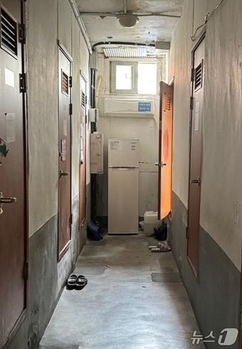 본문 이미지 - 2일 오전 서울 영등포구 영등포동 쪽방촌 문이 대부분 굳게 닫혀 있다. 복도 끝에서는 '서울시 공용 에어컨 7번'이 가동되고 있다. 25.07.02  ⓒ News1 송송이 기자
