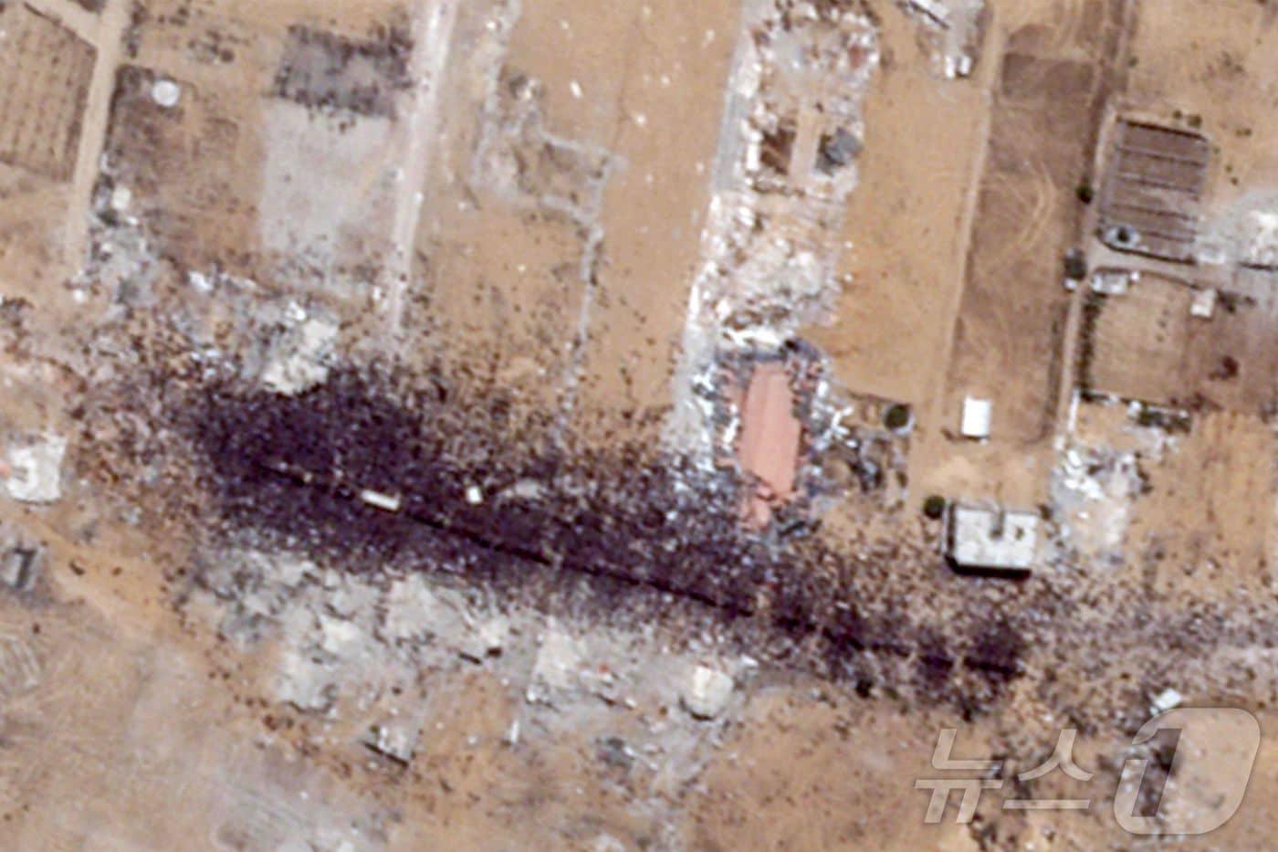 2025년 7월 26일 플래닛랩스가 촬영한 이 위성 사진은 미국이 지원하고 이스라엘이 지원한 가자인도주의재단&#40;GHF&#41; 배급소에서 남부 가자 지구 칸 유니스까지 약 1.2㎞ 동남쪽에 위치한 곳에서 트럭 주위와 위에 모여 있는 대규모 인파를 보여준다. 2025.7.26 ⓒ AFP=뉴스1 ⓒ News1 강민경 기자