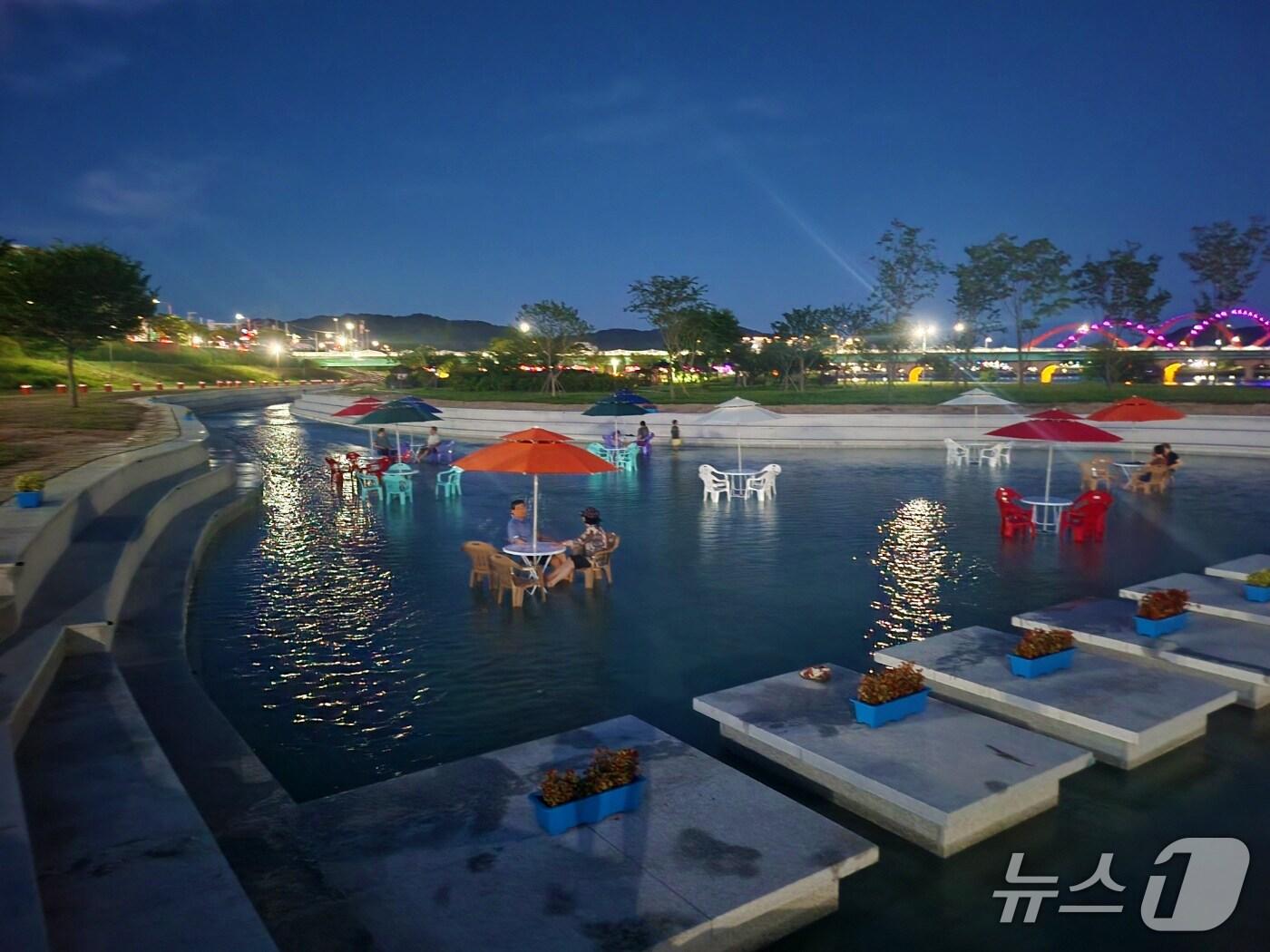 본문 이미지 - 안동 탈춤공원 앞 강변에 '물속 걷는 길'에서 시민들이 물에 발을 담그고 더위를 식하고 있다.(안동시 제공. 재판매 및 DB 금지)2025.7.30/뉴스1