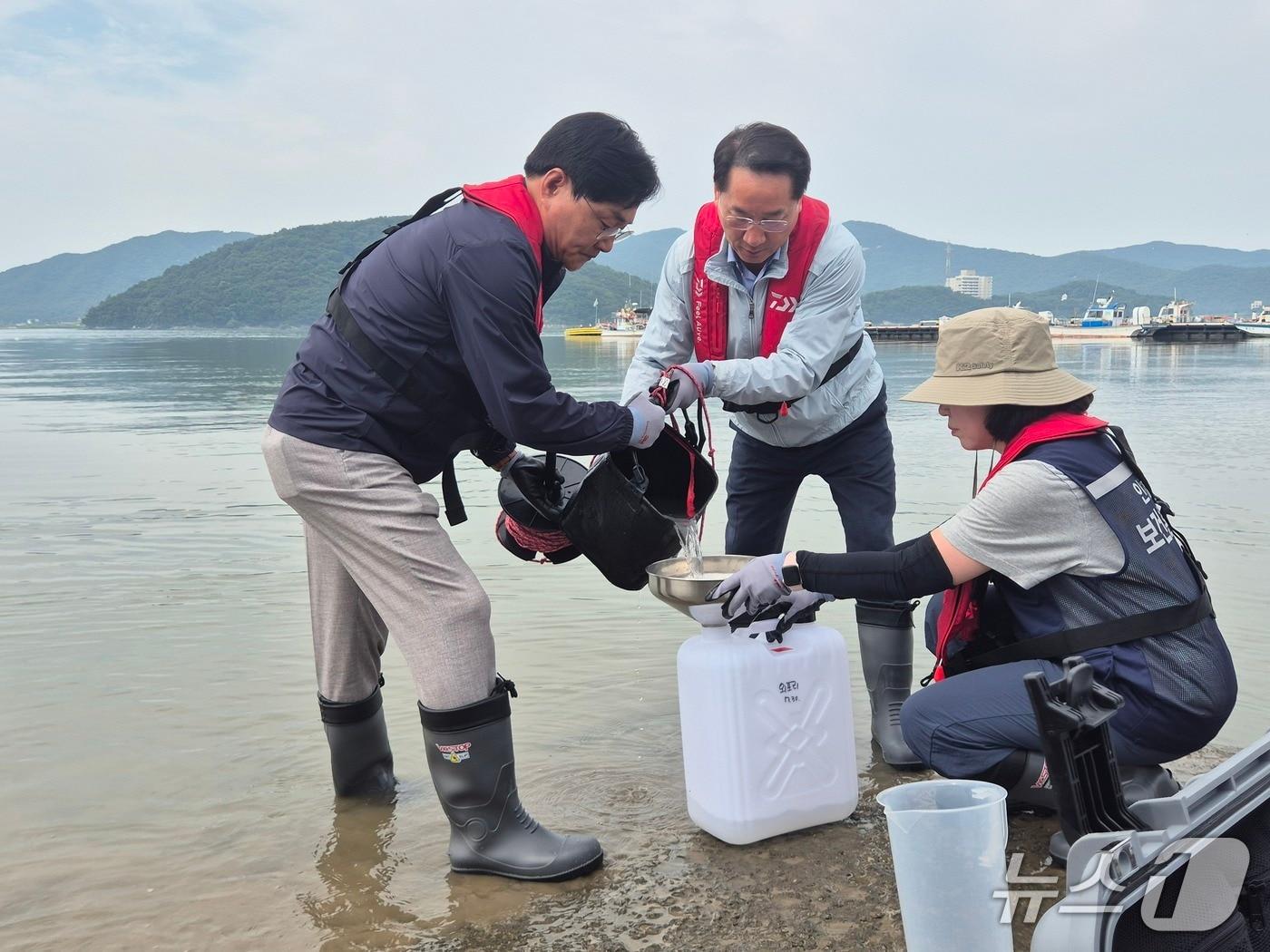 본문 이미지 - 유정복 인천시장(사진 가운데)와 박용철 강화군수(사진 왼쪽)이 30일 강화군 외포항 일대 연안에서 직접 해수를 채취하고 있다.이시명기자/뉴스1