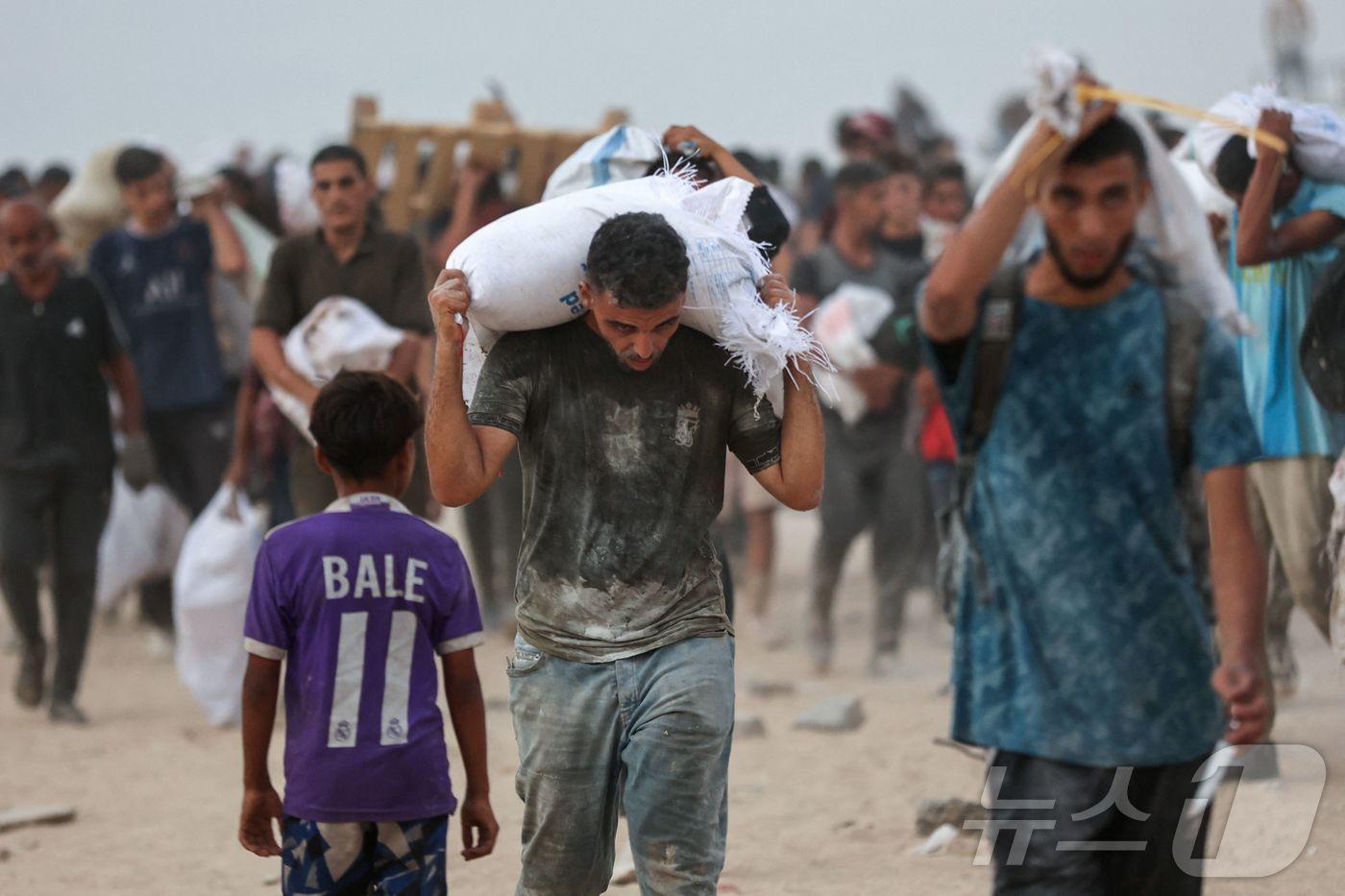 구호품을 운반 중인 팔레스타인 주민들. 2025.07.29. ⓒ AFP=뉴스1 ⓒ News1 유채연 기자