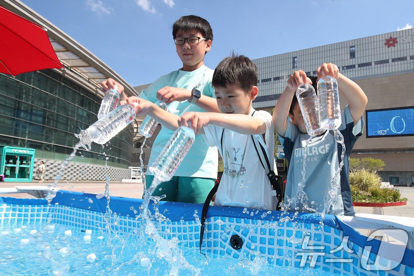 삼복더위가 절정에 달한다는 중복을 맞아 30일 오후 대구 동구 동대구역 광장에서 열린 '건강한 여름나기 캠페인' 현장을 지나던 어린이들이 얼음 수조에서 청라수를 꺼내고 있다. 대구공공시설관리공단, 대구도시개발공사, 한국철도공사 동대구역, V-파트너 대학생봉사단 등 대구기업자원봉사협의체와 달구벌원팀 회원단체는 시민들의 건강하고 안전한 여름나기를 위해 이날 청라수와 여름용품 등을 무료로 배부했다. 2025.7.30/뉴스1 ⓒ News1 공정식 기자