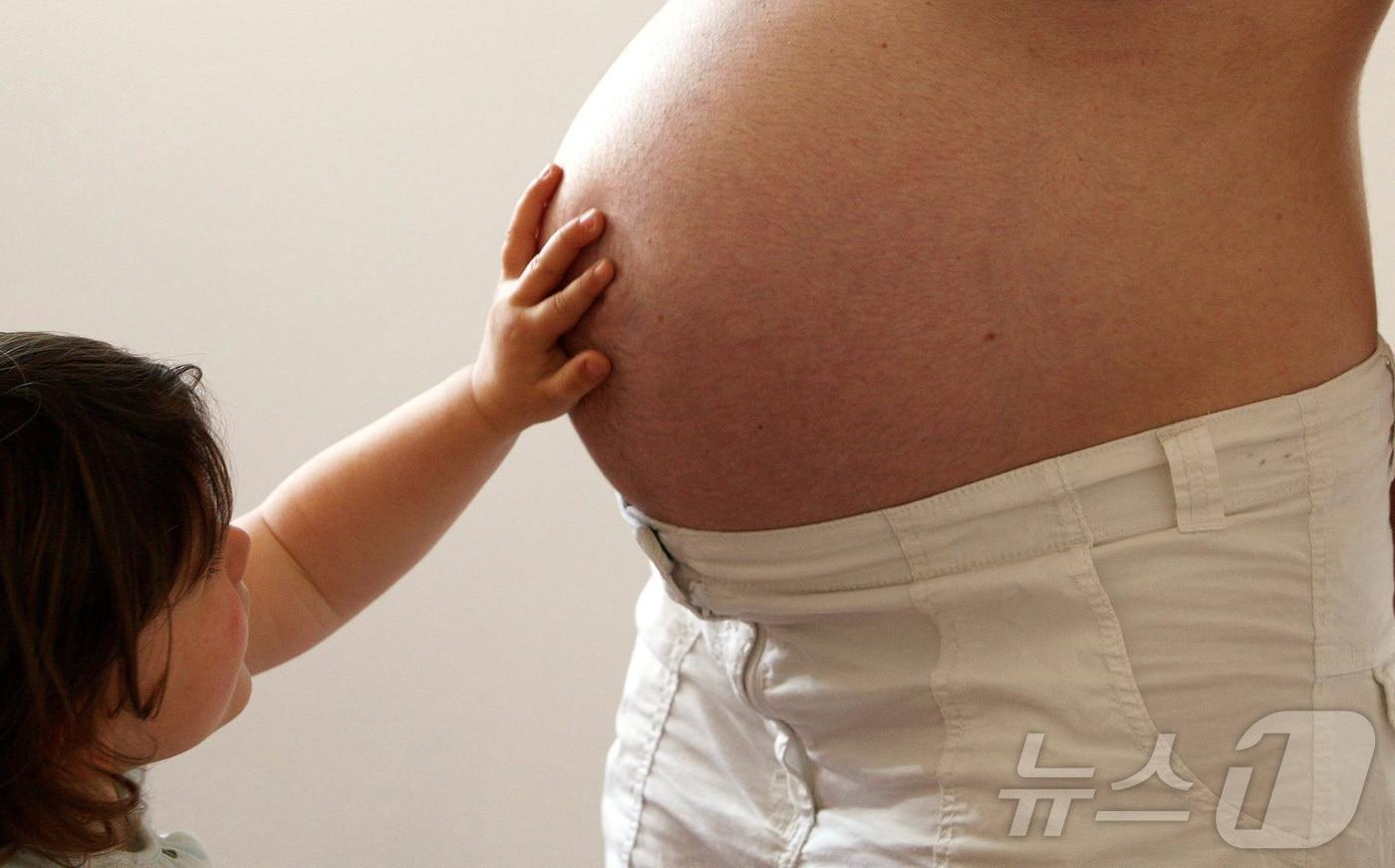 한 아이가 임신부의 배에 손을 올리고 있다. (특정 기사 내용과는 무관한 자료사진) 2025.04.08. ⓒ 로이터=뉴스1 ⓒ News1 유채연 기자