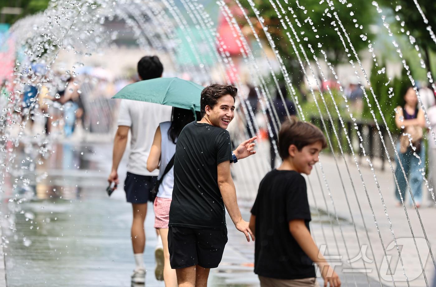 서울 종로구 광화문 광장을 찾은 관광객이 바닥분수에서 더위를 식히고 있다. /뉴스1 ⓒ News1 김도우 기자