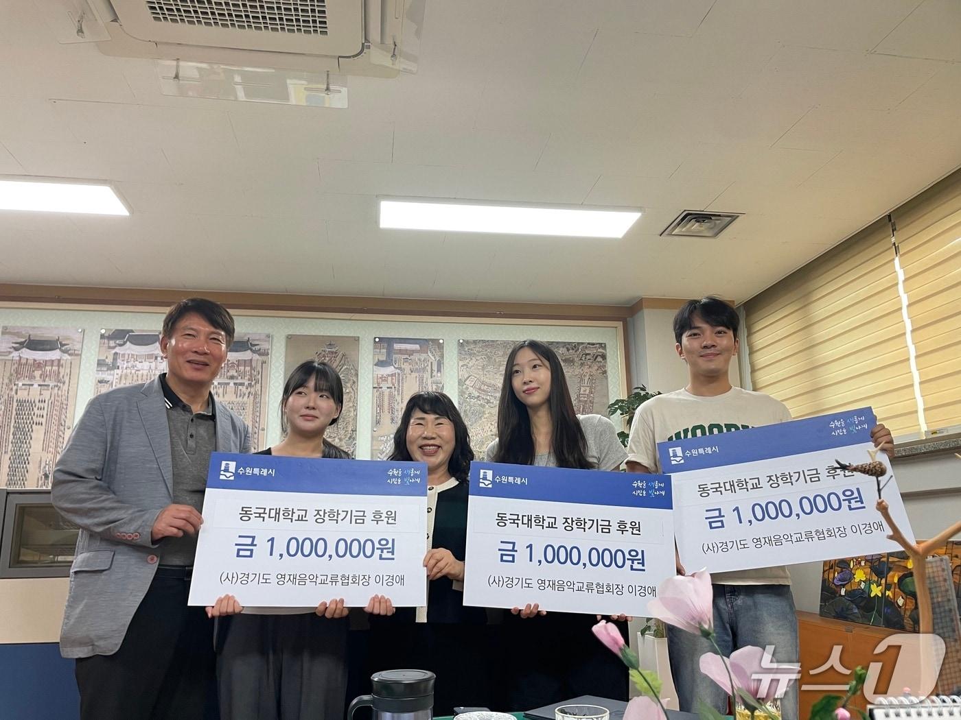 본문 이미지 - (사)경기도영재음악교류협회 이경애 회장(가운데)이 장학금을 전달한 뒤 수혜 학생 및 관계자들과 기념촬영을 하고 있다. 