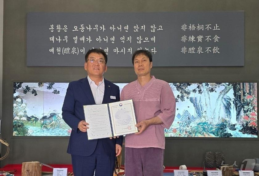 본문 이미지 - 경북 김학동 예천군수가 국가무형유산 ‘궁시장’ 분야의 ‘이수자’로 최종 선정된 성주경 씨에게 선정패를 수여하고 있다. ⓒ News1 김대벽기자