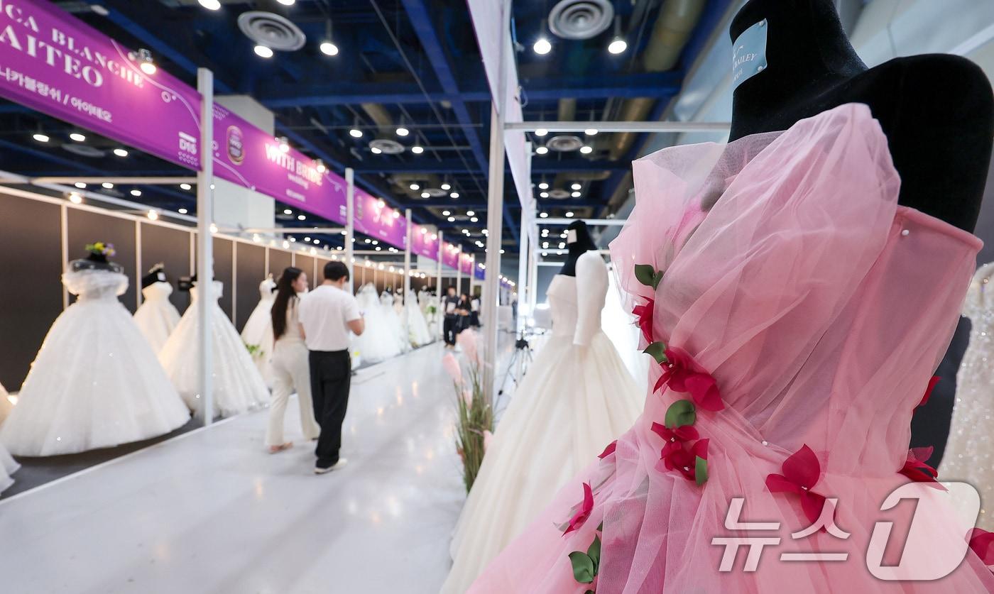 6일 서울 강남구 삼성동 코엑스에서 열린 2025 추계 웨덱스 웨딩 박람회에서 예비 부부들이 전시된 드레스를 살펴보고 있다.  (사진은 기사 내용과 무관함) 뉴스1 ⓒ News1 김성진 기자