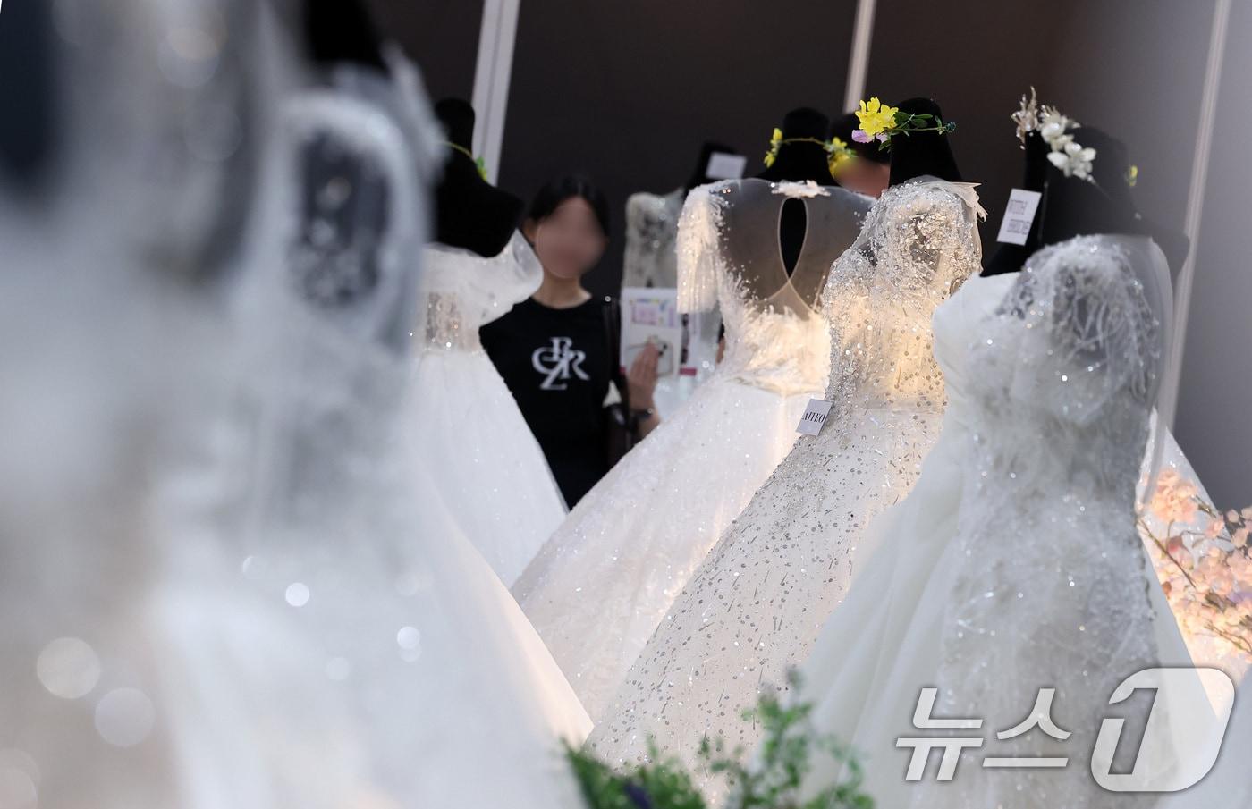 6일 서울 강남구 삼성동 코엑스에서 열린 2025 추계 웨덱스 웨딩 박람회에서 예비 부부들이 전시된 드레스를 살펴보고 있다. 2025.7.6/뉴스1 ⓒ News1 김성진 기자