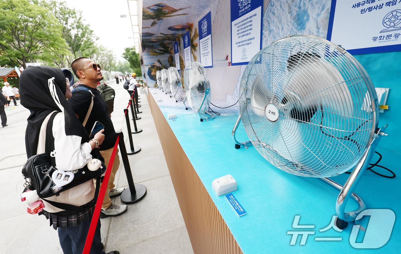 절기상 본격적인 더위가 시작된다는 소서(小暑)이자 서울 전역에 첫 폭염경보가 내려진 7일 서울 광화문광장에서 더위에 지친 외국인들이 선풍기 바람을 맞고 있다. 2025.7.7/뉴스1 ⓒ News1 김민지 기자