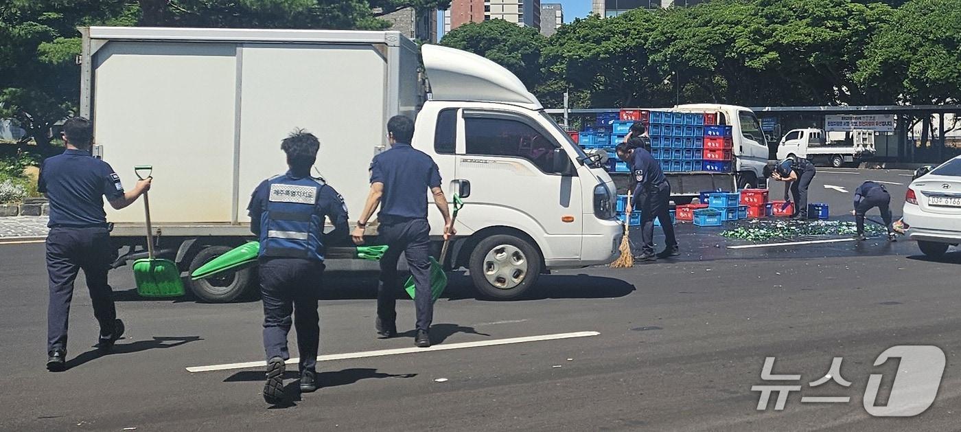 소주병이 쏟아진 사고 현장을 수습하는 제주도청 청원경찰들.(제주도 제공. 재판매 및 DB 금지)