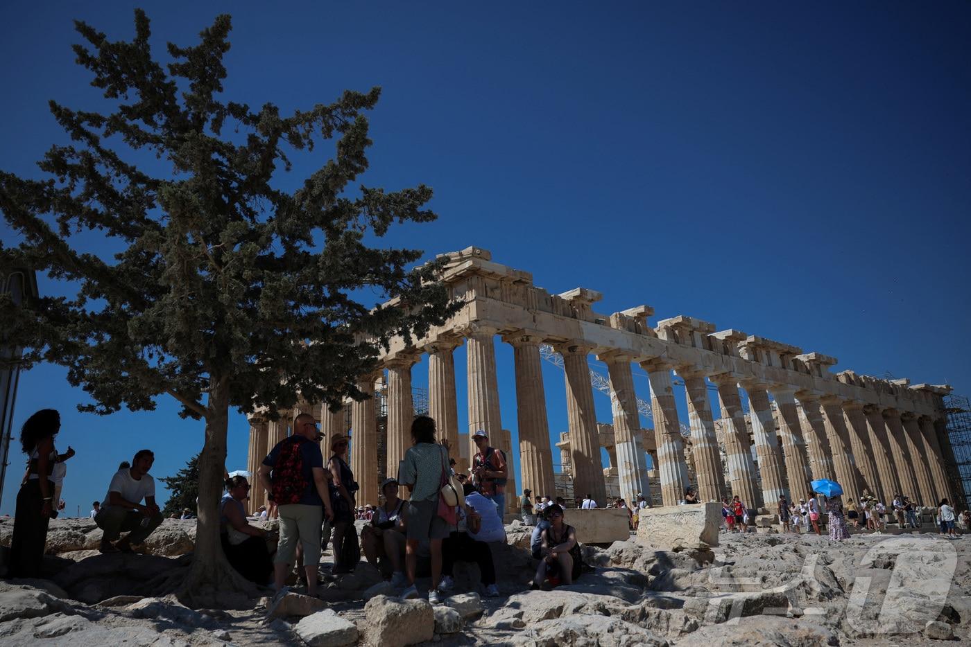 7일(현지시간) 그리스 아테네 아크로폴리스를 찾은 관광객들이 더위를 피해 나무 그늘 아래 모여 있다. 2025.07.07. ⓒ 로이터=뉴스1 ⓒ News1 윤다정 기자