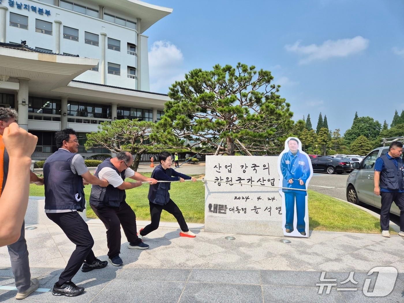 본문 이미지 - 민주노총 경남본부가 8일 창원시 성산구 산업단지공단 경남본부 앞에서 기자회견을 열고 윤석열 전 대통령 친필 표지석 철거를 촉구하는 퍼포먼스를 하고 있다. ⓒ 뉴스1 박민석 기자