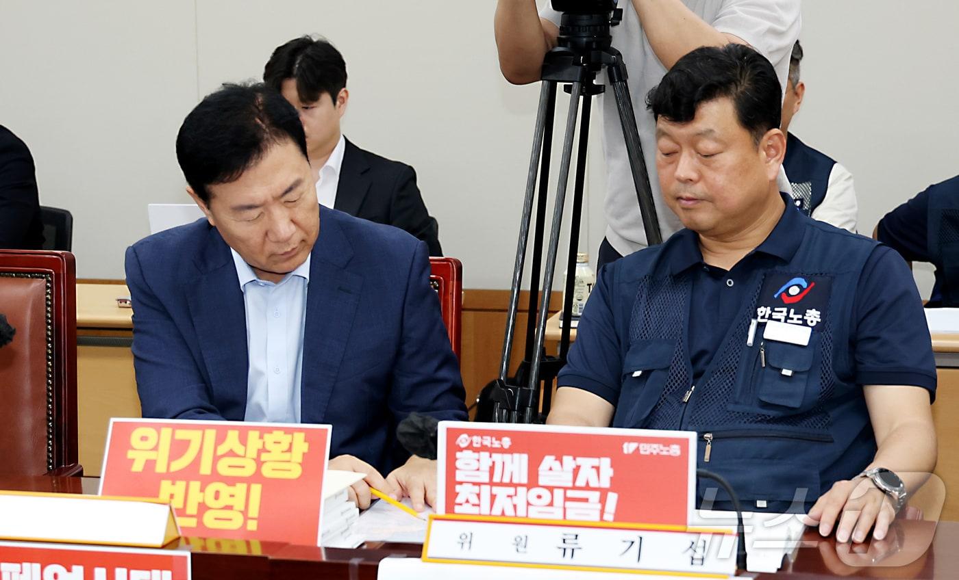 8일 세종시 정부세종청사 고용노동부에서 열린 최저임금위원회 제10차 전원회의에서 류기섭 사용자위원과 류기정 근로자위원이 메모지에 무엇인가를 적으며 이야기를 나누고 있다. 2025.7.8/뉴스1 ⓒ News1 김기남 기자