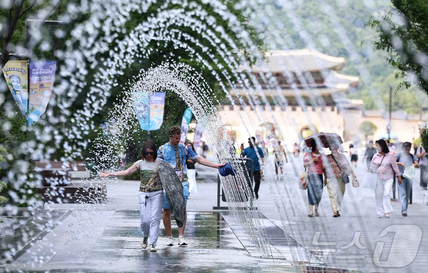 서울 종로구 광화문광장을 찾은 관광객이 바닥분수에서 더위를 식히고 있다. 2025.7.9/뉴스1 ⓒ News1 김도우 기자