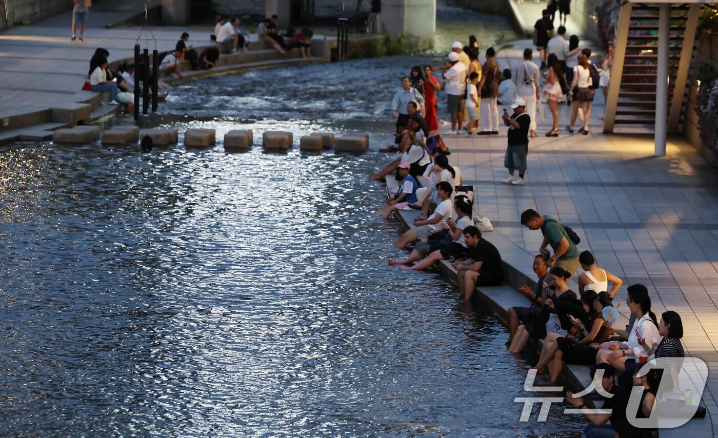 이른 폭염과 함께 열흘 넘게 열대야가 이어지고 있는 9일 시민들이 천변에서 더위를 식히고 있다. 2025.7.9/뉴스1 ⓒ News1 장수영 기자