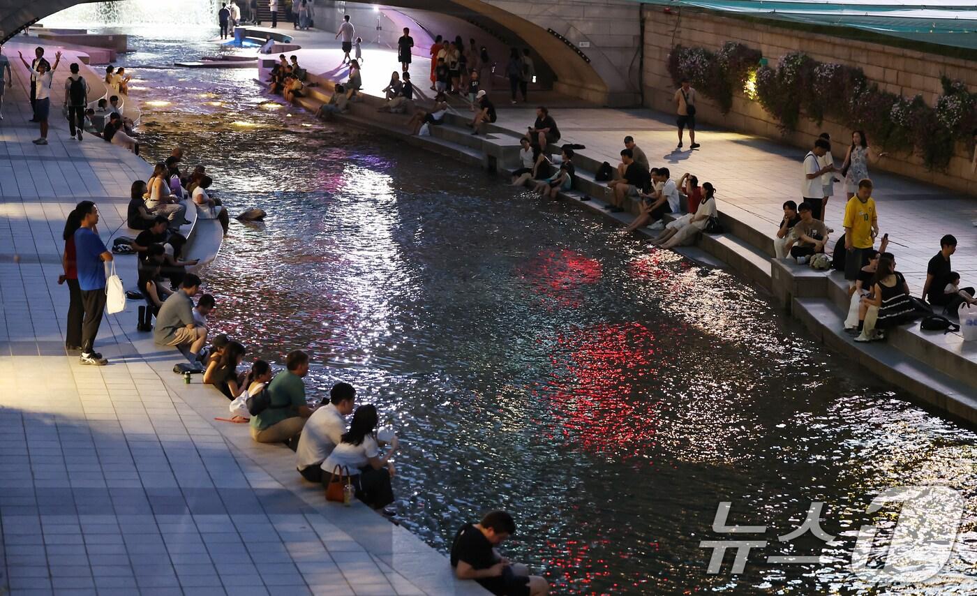 이른 폭염과 함께 열흘 넘게 열대야가 이어지고 있는 9일 저녁 서울 중구 청계천을 찾은 시민들이 더위를 식히고 있다. 2025.7.9/뉴스1 ⓒ News1 장수영 기자