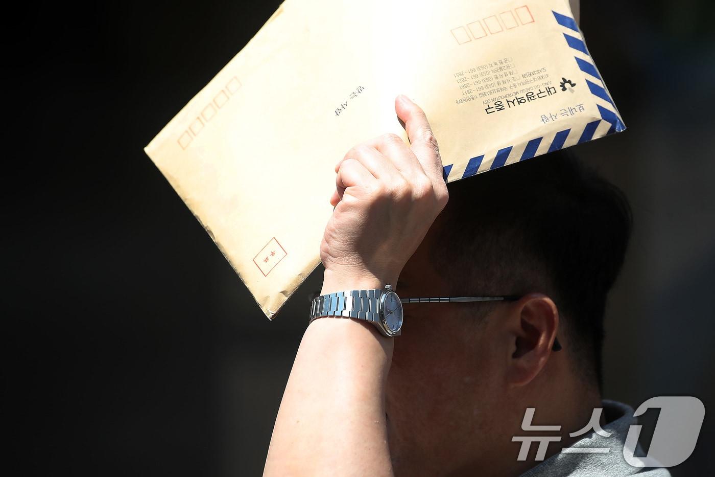 한 시민이 서류 봉투로 뙤약볕을 가린 채 발걸음을 옮기고 있다. 2025.8.1/뉴스1 ⓒ News1 공정식 기자