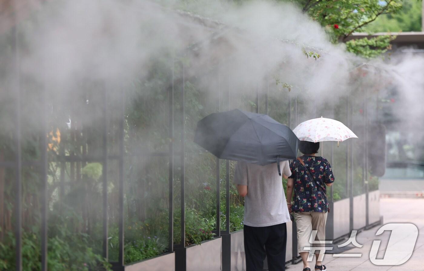 무더위가 이어진 1일 시민들이 서울 중구 서울시청 앞 쿨링포그를 지나고 있다. 2025.8.1/뉴스1 ⓒ News1 김도우 기자