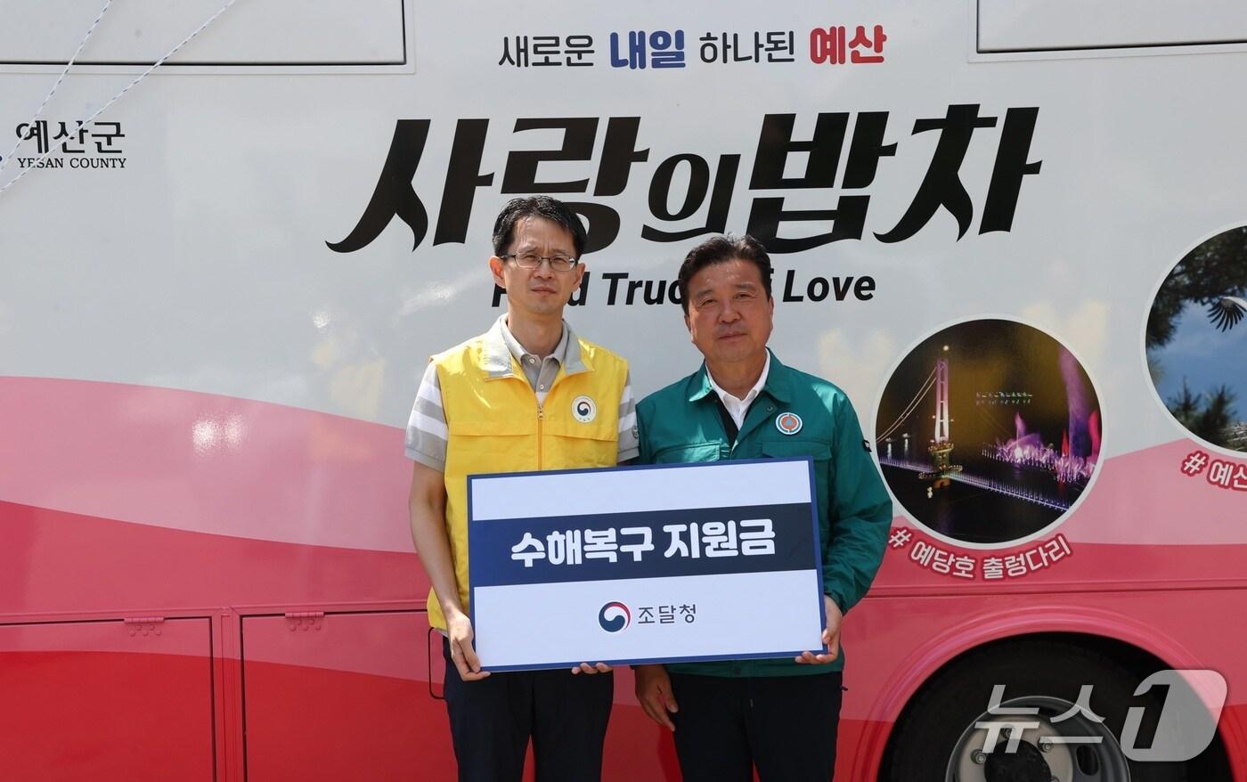 백승보 조달청 차장(왼쪽)이 1일 최근 폭우로 인해 피해를 본 예산군을 방문해 직원들이 자발적으로 모은 성금을 최재구 예산군수에게 전달하고 있다. (조달청 제공.재판매 및 DB금지)/뉴스1 