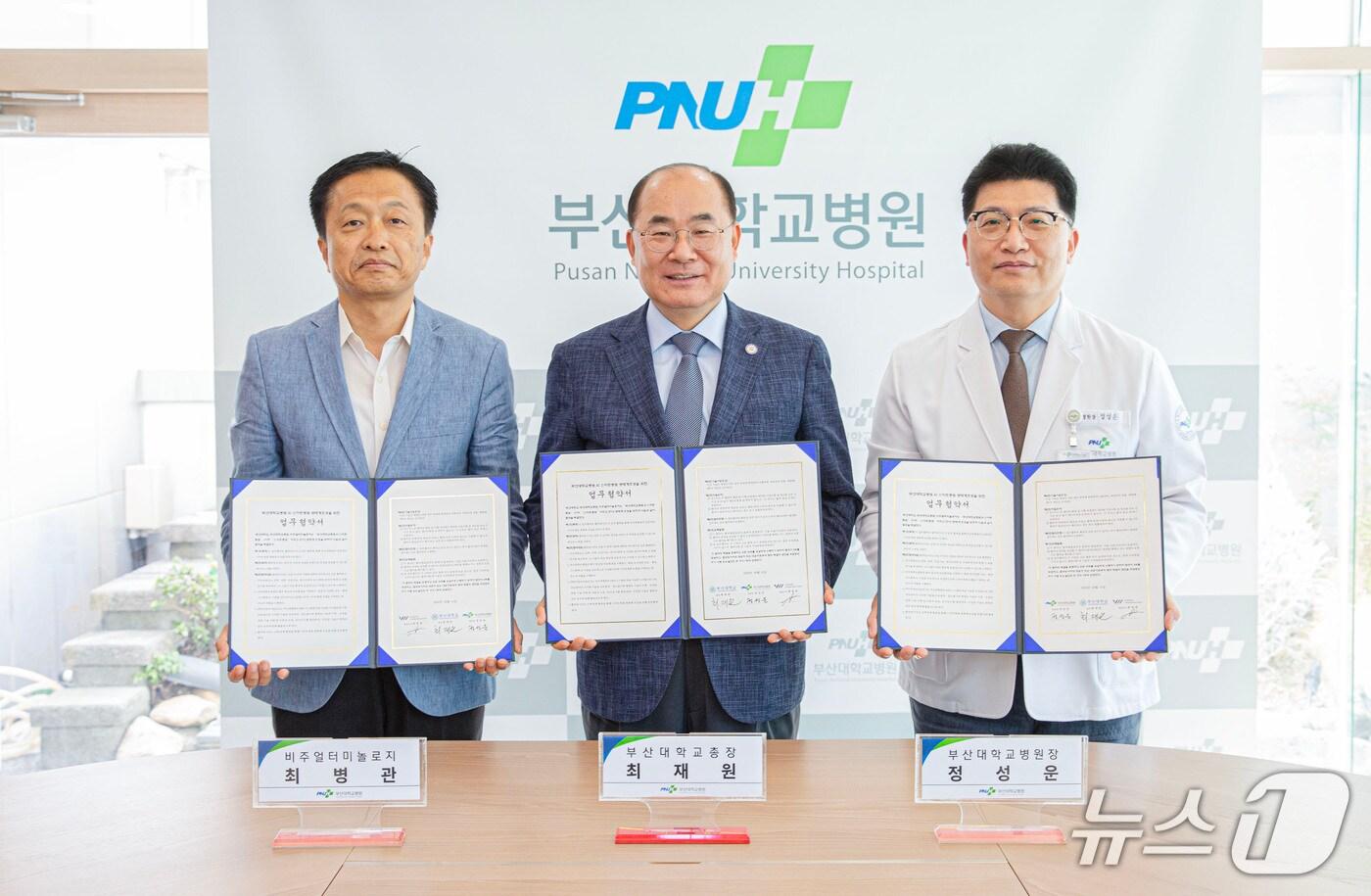 1일 부산 서구 부산대병원 J동 회의실에서 열린 ‘스마트병원 생태계 조성’을 위한 협약식에서 정성운 부산대병원장(오른쪽부터), 최재원 부산대 총장, 최병관 비주얼터미놀로지 대표가 협약서를 들어 보이고 있다. (부산대병원 제공. 재판매 및 DB 금지)