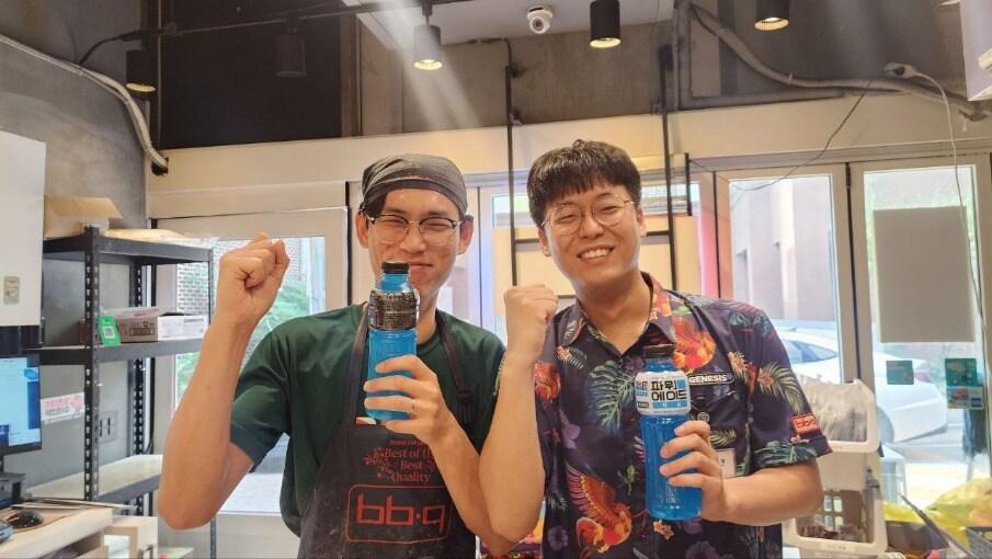 본문 이미지 - 지난 9일 한 BBQ 매장에서 수박·음료를 전달한 본사 직원과 이를 받은 가맹점주가 기념촬영을 하고 있다&#40;제너시스BBQ 제공&#41;.