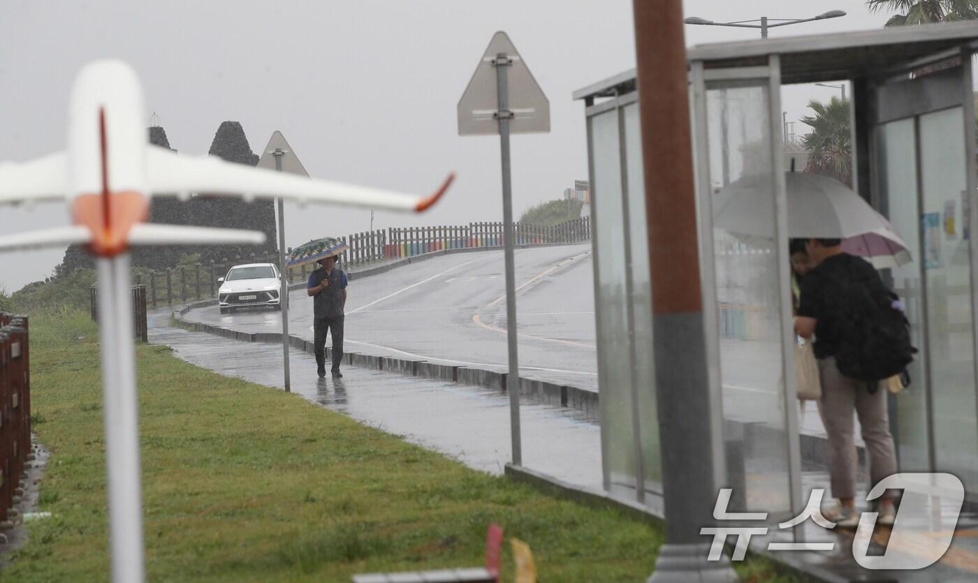 오전 제주시 용담해안도로에서 우산을 쓴 관광객들이 발걸음을 옮기고 있다. 2025.8.11/뉴스1 ⓒ News1 오현지 기자