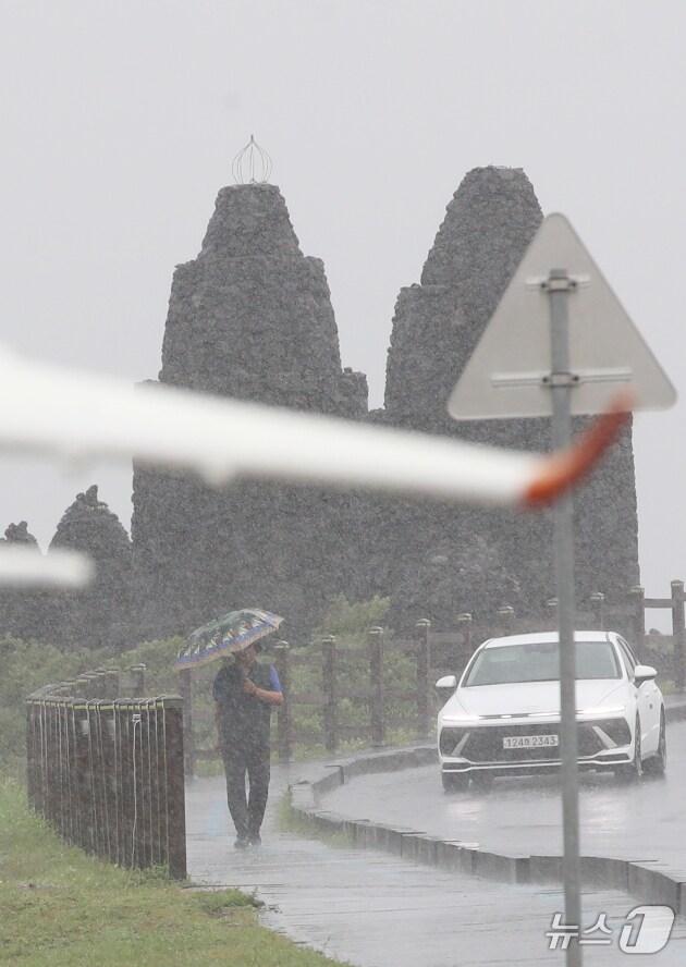 본문 이미지 -  제주시 용담해안도로에서 우산을 쓴 행인이 발걸음을 옮기고 있다. 2025.8.11/뉴스1 ⓒ News1 오현지 기자