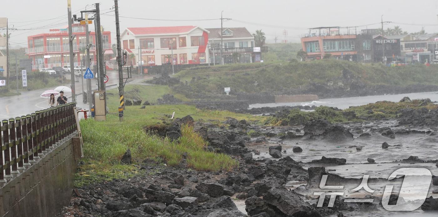 제주시 용담해안도로에서 우산을 쓴 관광객들이 발걸음을 옮기고 있다. 2025.8.11/뉴스1 ⓒ News1 오현지 기자