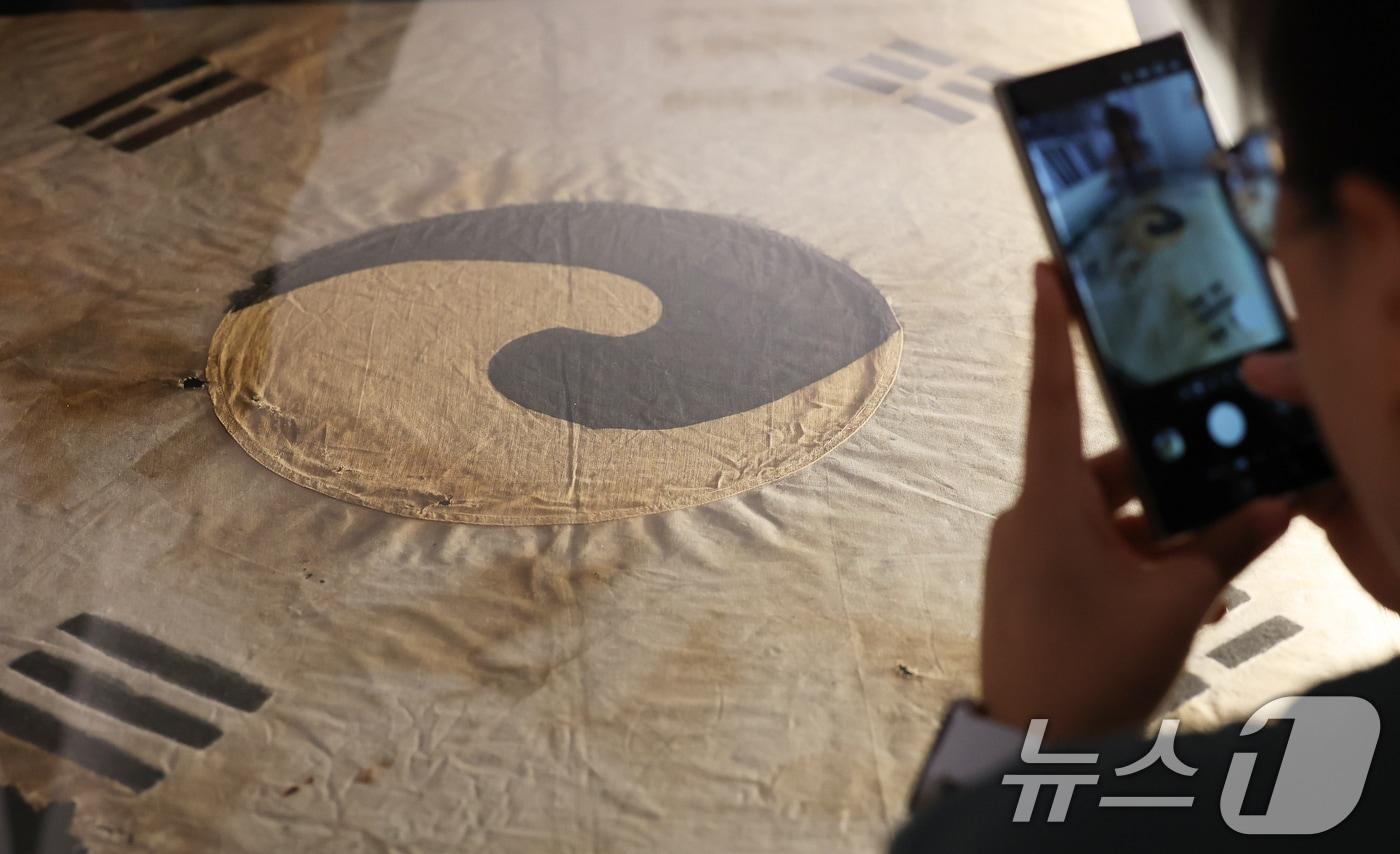 11일 오전 서울 중구 덕수궁 돈덕전에서 열린 &#39;빛을 담은 항일유산&#39; 특별전 언론공개회에서 방문객들이 일제강점기 당시 일장기를 먹으로 덧칠해 만든 &#39;서울 진관사 태극기&#39;를 살펴보고 있다. 2025.8.11/뉴스1 ⓒ News1 오대일 기자