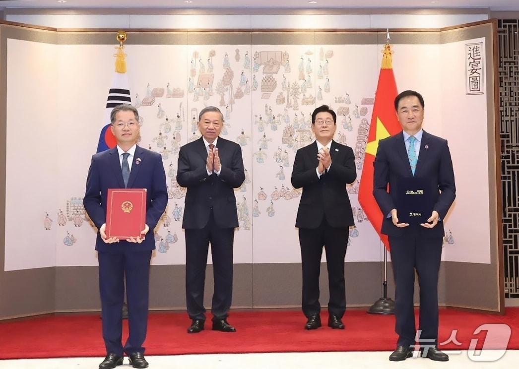 본문 이미지 - 정장선 평택시장&#40;사진 오른쪽 첫번째&#41;과 응우옌 반 꽝 다낭시 당서기가 이재명 대통령과 또 럼 베트남 서기장이 지켜보는 가운데 합의서를 교환하고 있다&#40;평택시 제공&#41; 