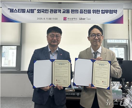 본문 이미지 - 11일 부산시청에서 김현재 부산시 관광마이스국장(왼쪽)과 송진우 우버 택시코리아 총괄이 업무협약서에 서명하고 기념 촬영하고 있다.(부산시 제공. 재판매 및 DB금지)