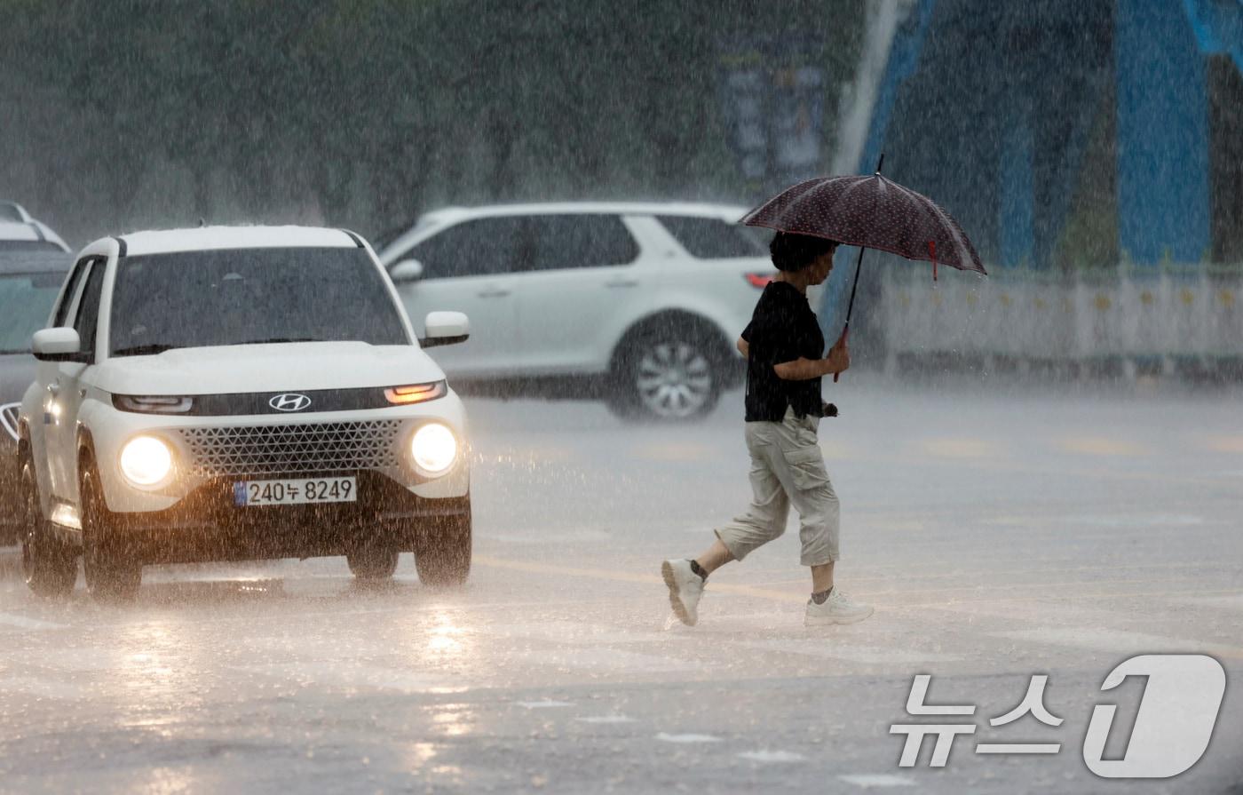 광주시 서구 상무지구에서 우산을 쓴 시민이 조심스럽게 길을 건너고 있다. 2025.8.12/뉴스1 ⓒ News1 김태성 기자