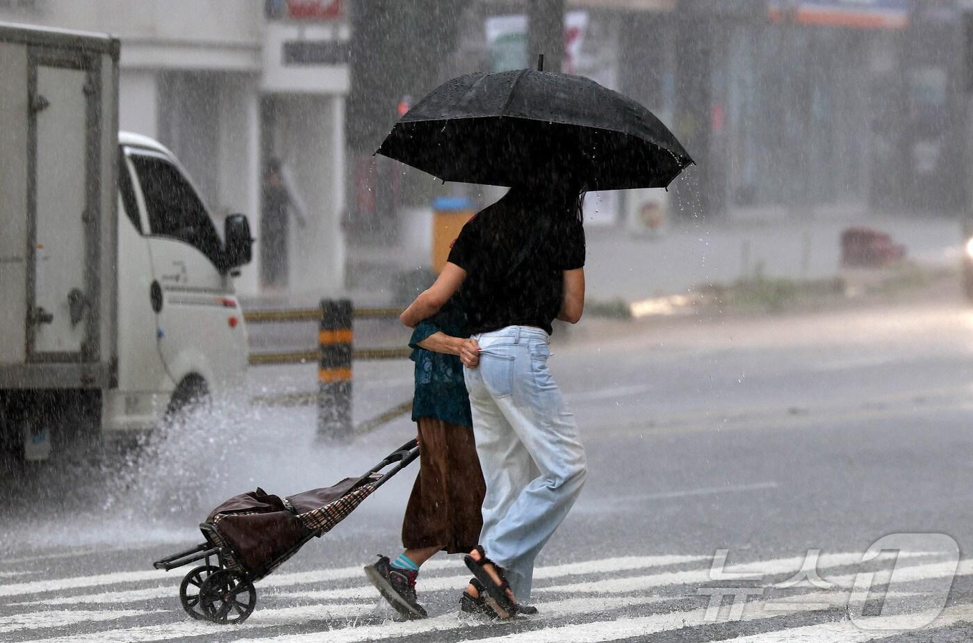 한 행인이 우산을 준비 못한 할머니 한분과 함께 우산을 같이 쓰며 횡단보도를 건너고 있다.(사진은 기사 내용과 무관함) / 뉴스1 ⓒ News1