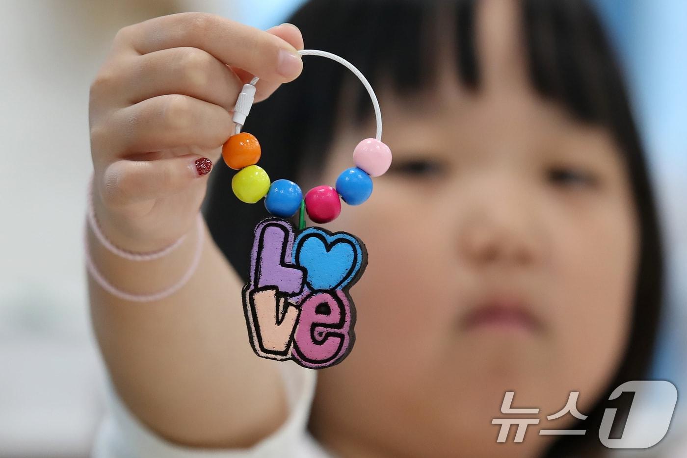 본문 이미지 - 초등학생들이 커피박(찌꺼기) 업사이클링을 통해 직접 만든 키링을 보여주고 있다.ⓒ 뉴스1 공정식 기자
