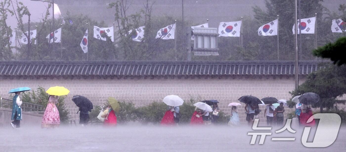호우특보가 발효된 13일 서울 종로구 국립고궁박물관 인근에서 외국인 관광객들이 우산을 쓴 채 발걸음을 옮기고 있다. 2025.8.13/뉴스1 ⓒ News1 박지혜 기자