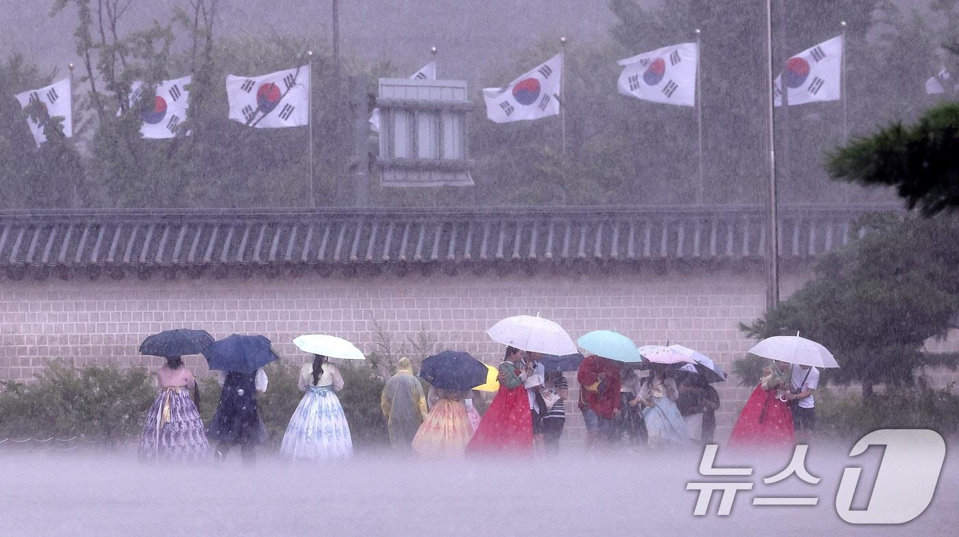 호우특보가 발효된 13일 서울 종로구 국립고궁박물관 인근에서 외국인 관광객들이 우산을 쓴 채 발걸음을 옮기고 있다. 2025.8.13/뉴스1 ⓒ News1 박지혜 기자