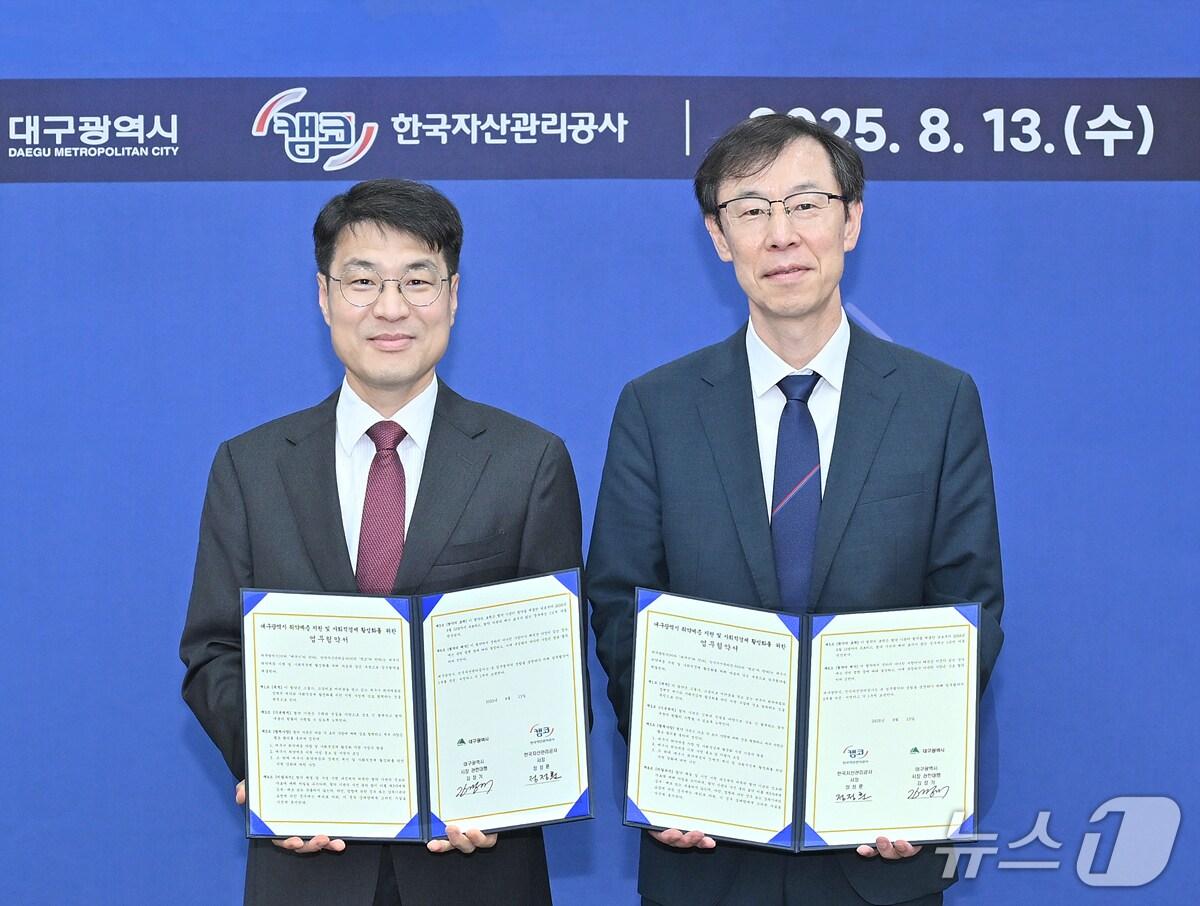 본문 이미지 - 김정기 대구시장 권한대행 행정부시장&#40;완쪽&#41;과 정정훈 한국자산관리공사 사장이 금융취약계층 지원 및 사회적경제 활성화를 위한 업무협약을 체결한 후 협약서를 펼쳐 보이고 있다.&#40;대구시 제공. 재판매 및 DB 금지&#41;