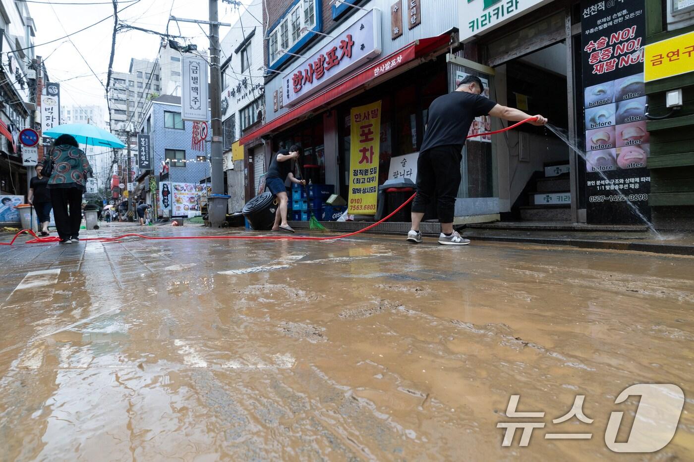 13일 오후 서울 은평구 연신내역 인근 상가 거리에서 상인들이 폭우로 인해 더러워진 거리를 청소하고 있다. 2025.8.13/뉴스1 ⓒ News1 이승배 기자